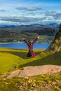 Young Pretty Girl Jumps Happily From Rock In Front Of Spectacular Landscape Of Applecross Pass In Scotland