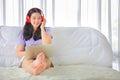 Young pretty girl listening to music from home on her bed using computer laptop to access media online Royalty Free Stock Photo