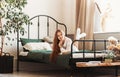 A young pretty girl with long hair lies on a bed in the bedroom. Day rest and relaxation Royalty Free Stock Photo