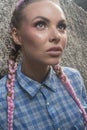 Young pretty girl with pink plaits between rocks