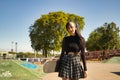 Young pretty girl with punk style and heterochromia holding a skateboard with her hand looking at the camera in a skateboard park Royalty Free Stock Photo