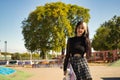 Young pretty girl with punk style and heterochromia holding a skateboard with her hand looking at the camera smiling at a Royalty Free Stock Photo