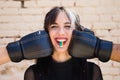 Young and pretty girl with a punkish tendency. She is being hit on each side of her face with boxing gloves while holding a jelly Royalty Free Stock Photo