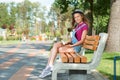 Young pretty girl sitting on the bench keeping a book. Royalty Free Stock Photo