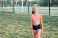 Young pretty girl of a slim body building, dressed in a sports uniform, spends time on a sports ground Royalty Free Stock Photo