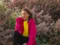 A young pretty girl sneezes near the flowering trees. The concept of spring allergy. The girl is allergic to pollen of flowers Royalty Free Stock Photo