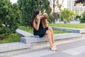 Pretty girl and her pet, little golden poodle dog strolling in public park, outdoors. Summer time. Sincere emotions