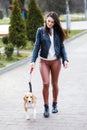 Young pretty girl walking her cute dog in the park. The girl actively spends her leisure Royalty Free Stock Photo