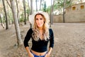 Young pretty girl walking through a park at sunset with jeans and hat, looking attractive Royalty Free Stock Photo