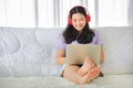 Young pretty girl watching movie from home on her bed using computer laptop to access media online Royalty Free Stock Photo