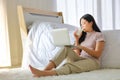 Young pretty girl working from home on her bed using computer laptop Royalty Free Stock Photo