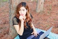 young pretty girl working on laptop outdoor and eating strawberry Royalty Free Stock Photo