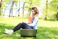 Young pretty girl working on laptop outdoor, lying on grass, caucasian 20 years old Royalty Free Stock Photo