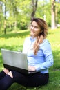 Young pretty girl working on laptop outdoor, lying on grass, caucasian 20 years old Royalty Free Stock Photo