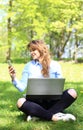 Young pretty girl working on laptop outdoor, lying on grass, caucasian 20 years old Royalty Free Stock Photo