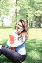 Young pretty girl working on laptop outdoor, lying on grass, caucasian 20 years old Royalty Free Stock Photo