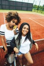 Young pretty girlfriends hanging on tennis court, fashion stylish dressed swag, best friends happy smiling together Royalty Free Stock Photo