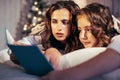 Young pretty girls in bed at Christmass morning, happy family smiling lifestyle at holiday reading book