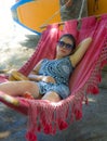 Young pretty happy Asian Chinese woman lying lazy on beach hammock sun bed relaxed and cheerful in Summer holiday trip enjoying va Royalty Free Stock Photo