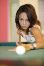 young pretty and happy Asian girl playing snooker holding stick at pool table in night club or bar Royalty Free Stock Photo