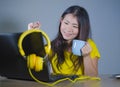 Young pretty and happy Asian Korean woman at desk enjoying internet on laptop computer smiling cheerful having fun drinking tea cu Royalty Free Stock Photo