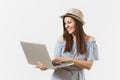 Young pretty happy woman in blue dress, hat working on modern laptop pc computer isolated on white background. People Royalty Free Stock Photo