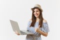 Young pretty happy woman in blue dress, hat working on modern laptop pc computer isolated on white background. People Royalty Free Stock Photo