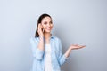 Young pretty happy woman on gray background gossiping on smartphone with her best friend Royalty Free Stock Photo