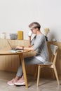 Young pretty hipster millennial female working with laptop in cafe interior