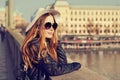 Young pretty hipster tourist cheerful girl posing on the street at sunny day and traveling around european city