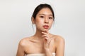 Young pretty korean lady enjoying perfect soft skin after spa procedures, posing on white background