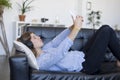 Young pretty long hair woman lying on a sofa making selfie on he Royalty Free Stock Photo