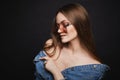 Young model woman in cool pink sunglasses and denim jacket posing on black isolated background. Attractive girl with Royalty Free Stock Photo