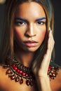Young pretty modern african american girl with bright fashion makeup and ethnic jewelry