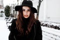 Young pretty modern hipster girl waiting on bench at winter snow park alone, lifestyle people concept Royalty Free Stock Photo