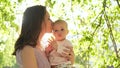 Young pretty mom play with small smiling laught toddler outside