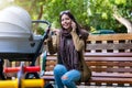 Mother with her newborn baby in the park talking on her mobile phone Royalty Free Stock Photo