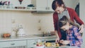 Young pretty mother teaching her cute daughter to cut vegetables properly. Little girl cooking together with loving mom Royalty Free Stock Photo