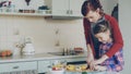 Young pretty mother teaching her cute daughter to cut vegetables properly. Little girl cooking together with loving mom Royalty Free Stock Photo
