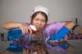 Young pretty overworked and frustrated Asian Chinese service maid woman working domestic cleaning and washing home kitchen stresse Royalty Free Stock Photo