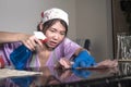 Young pretty overworked and stressed Asian Korean service maid woman working domestic cleaning and washing with spray bottle angry Royalty Free Stock Photo