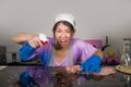 Young pretty overworked and stressed Asian Korean service maid woman working domestic cleaning and washing with spray bottle angry Royalty Free Stock Photo