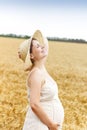 Young pretty pregnant woman outdoors on sunset in the field Royalty Free Stock Photo