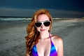 Young Pretty Red Haired Woman playing on a Beach