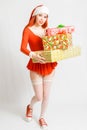Young and pretty red head girl in a Santa Claus mini dress on a neutral white backgroung