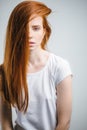 Young pretty redhead girl with freckles looking at camera smiling touching hair Royalty Free Stock Photo