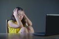 Young pretty shocked and surprised Asian Korean woman looking stressed at laptop computer feeling amazed and scared in cyber bully Royalty Free Stock Photo