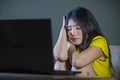 Young pretty shocked and surprised Asian Korean woman looking stressed at laptop computer feeling amazed and scared in cyber bully Royalty Free Stock Photo