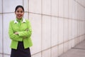 Young scort woman or crew smiling crossed arms green