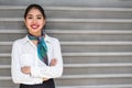 Young scort woman or crew smiling crossed arms green